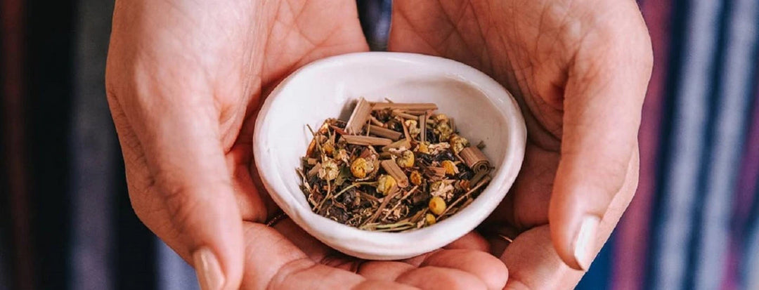 Person holding ground up tea leaves in a dish